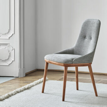 Exceptional Porada Connie chair with light gray woven textile upholstery and solid Canaletta Walnut wood frame