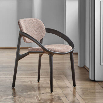 Distinguished Porada Molly armchair with a continuous canaletto walnut frame and neutral textured textile upholstery with matte finish