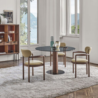 Elegant Porada Sansiro table with a clear glass top and a sculptural central leg crafted from canaletto walnut in Bronzoro finish