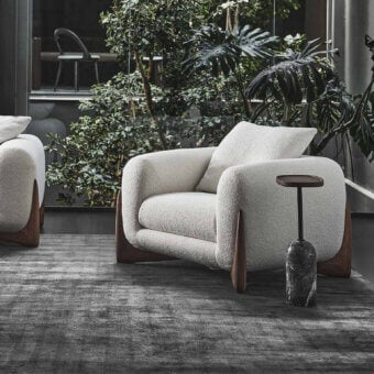 Exceptional Porada Softbay armchair with enveloping form, bouclé fabric upholstery and satin Canaletta walnut frame