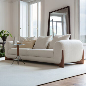 Distinguished Porada Softbay sofa with gently curved form and deeply cushioned seat in textured cotton, linen, and wool Bouclage with satin Canaletta walnut end-feet