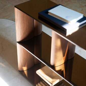Distinguished Potocco Pages bookshelf with sinuous solid ash wood uprights and transparent bronze mirrored glass shelves in a satin finish