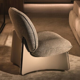 Exceptional Visionnaire Flame lounge chair with enveloping form, muted gray textile upholstery and satin stainless steel edging