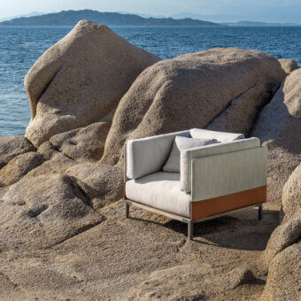 Distinguished Ethimo Baia lounge chair crafted in Italy with light beige cushions and warm brown fabric-upholstered panels