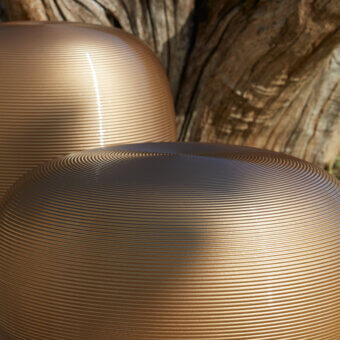 Elegant MY YOUR Pandora stool with rounded organic form crafted in golden-bronze metal featuring a satin finish