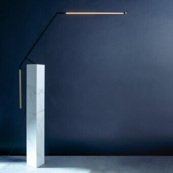 Elegant Nemo Bird table lamp in matte black metal with pale orange-yellow illuminated panel achieving balanced diffused light
