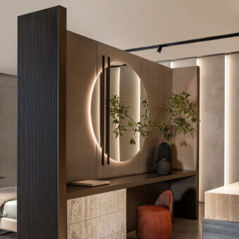 Distinguished Shake Line mirror with a circular reflection in varnished steel and textured beige detailing with integrated LED lighting