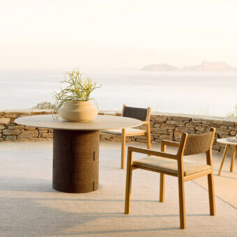 Harmonious Varaschin Gianna table with cylindrical aluminum base and bush-hammered ceramic tabletop in a light neutral tone