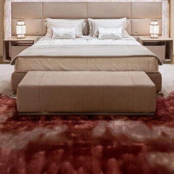 Refined Visionnaire Aubade bench with warm beige fabric upholstery and satin metal finishes on a solid wood frame