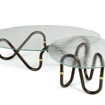 Elegant Borzalino Flow coffee table with clear glass top and continuously curved dark-toned metal base crafted with a brass joint ring