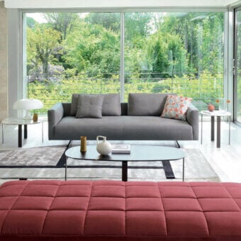 Exclusive CTS Salotti Ikon sofa with medium gray textile upholstery and patterned cushions in blue, orange, and white hues