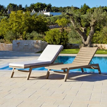 Sophisticated Ethimo Costes lounger crafted with FSC-certified teak and plush off-white cushions with a warm natural finish
