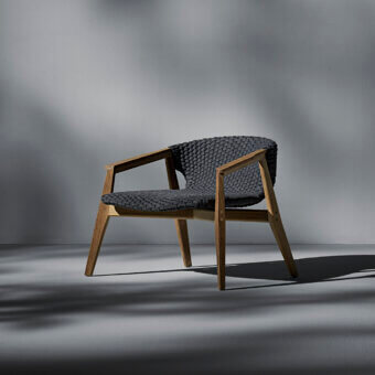 Distinguished Ethimo Knit lounge chair with a sinuous FSC-certified teak frame and dark gray high-density woven rope construction