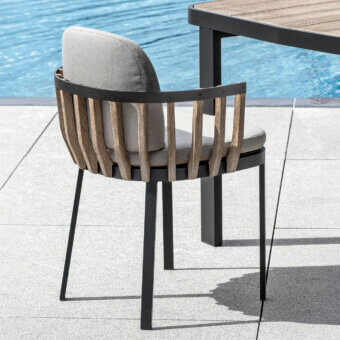 Distinguished Ethimo Swing armchair with a dark gray metal frame and precisely arranged teak slats, completed with light gray cushions