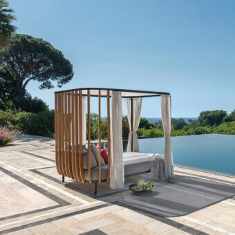 Architectural Ethimo Swing daybed crafted in Italy with teak slats, dark matte metal, plus neutral cushions and sheer fabric