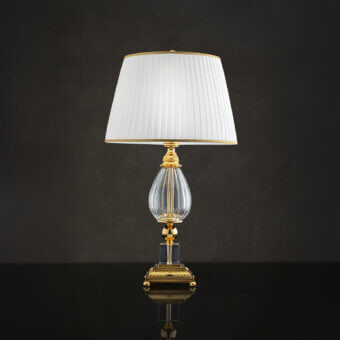 Distinguished Laudarte Cordelia table lamp crafted in Italy with bronze castings, clear crystal and 24K gold plating with an off-white lampshade