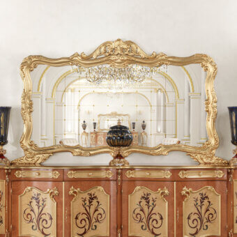 Exquisite Modenese Royal Blend mirror with ornate wood carvings and gold-colored finish including a cabinet with swirling floral motifs