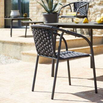 Elegant Roberti Rattan Capri armchair crafted with dark gray searope and powder-coated aluminum offering a curved silhouette