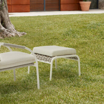 Handcrafted Roberti Rattan Capri pouf with light beige textile upholstery and powder-coated aluminum frame