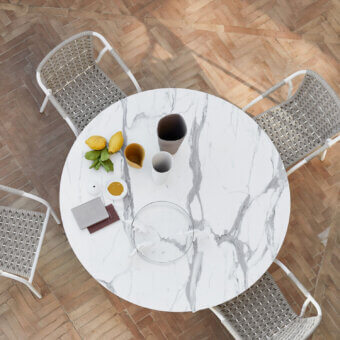 Distinguished Roberti Rattan Capri table with grey veined HPL top and decorative searope detailed powder-coated steel base crafted in Italy