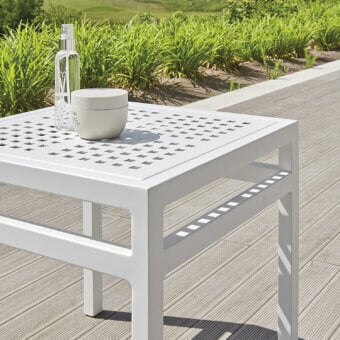 Distinctive Varaschin Victor side table crafted in Italy with matte white finish and refined perforations for outdoor use