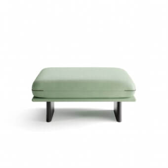 Exceptional Borzalino Connor ottoman in pastel green textile upholstery with refined black trim detailing and dark angled sled bases