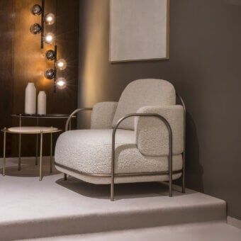Distinctive Carpanese Home Gaston lounge chair with creamy beige textured boucle upholstery and satin Brass painted metal structure