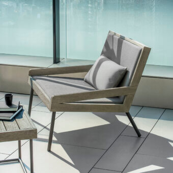 Distinguished Ethimo Allaperto lounge chair with angular form and muted gray textile upholstery in a matte grayish-brown wood frame