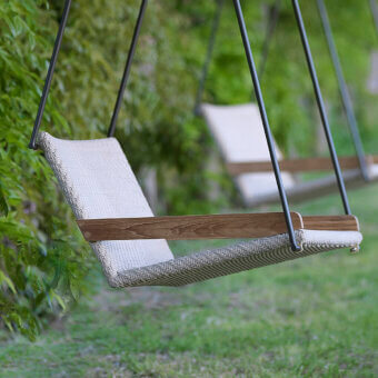 Architectural Ethimo Allaperto Swing lounge with dark gray metal frame and light gray woven textile complemented by warm brown wood