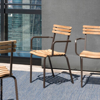 Refined Ethimo Laren armchair with warm brown wood and dark matte metal, crafted in a contemporary silhouette with satin finish