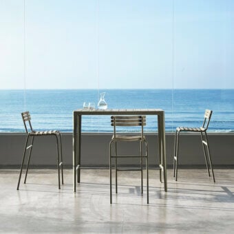 Sophisticated Ethimo Laren bar table with sleek metal frame and warm teak slats in muted olive green matte finish