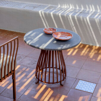 Exceptional Ethimo Venexia coffee table with a speckled grey stone tabletop and reddish-brown satin aluminum slats
