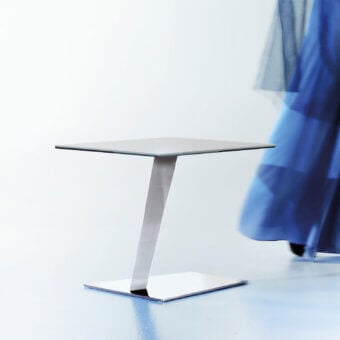 Distinguished Naos Calypso side table with smooth glass tabletop and polished neutral gray metal base