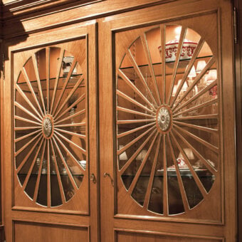 Architectural Provasi 1221 bookcase crafted in noble wood with warm brown finish and ornate brass details