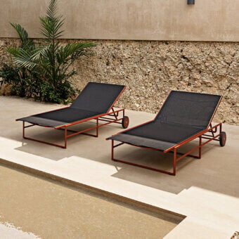 Distinguished Atmosphera Pipe Lounger featuring a reddish-brown tubular steel frame with a breathable black textilene seat for outdoor use