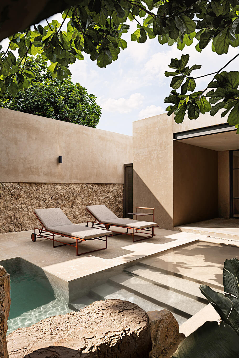 Elegant Atmosphera Pipe Lounger, a low form built with reddish-brown tubular steel and breathable gray textilene upholstery