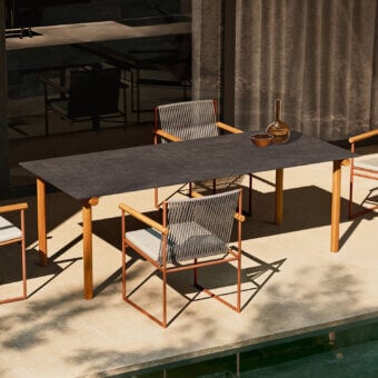 Architectural Atmosphera Pipe table with dark gres and solid Asian teak legs crafted with a satin finish