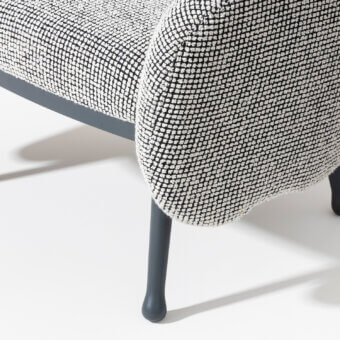 Elegant Billiani Corolla lounge chair with enveloping form and patterned textile upholstery built with worked wood and matte gray metal legs