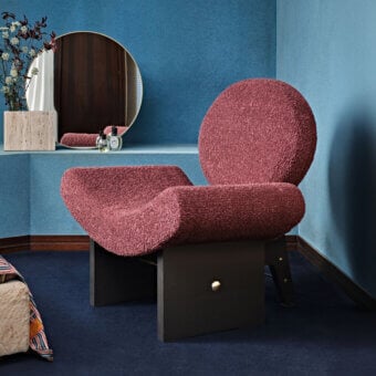 Distinctive Black Tie Onika lounge chair with muted rose textile upholstery and a dark-toned wood base accented with gilded details