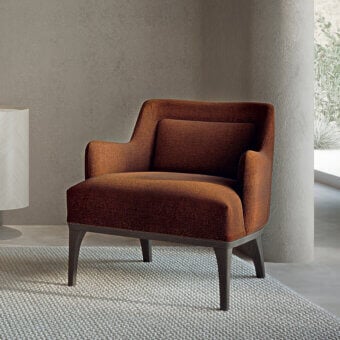 Elegant Carpanelli Ara lounge chair upholstered in reddish-brown textured textile with a satin-finish solid wood frame