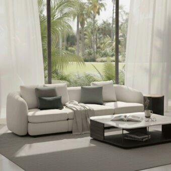 Elegant Carpanelli Grantour sofa with smooth textile upholstery in off-white and teal-green cushions and rounded edges
