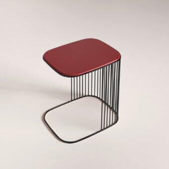 Elegant Frag Comb side table with a matte black metal base and reddish-burgundy tabletop in gloss finish