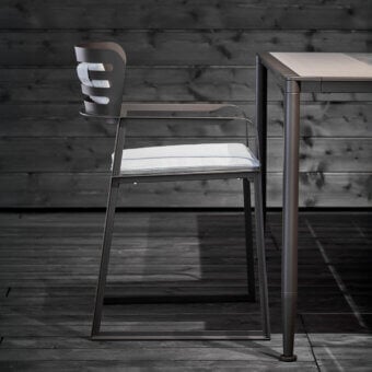 Architectural Giorgetti Gea armchair with a geometric stainless steel frame in carob finish and light gray woven birch seat