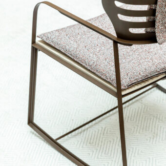 Sophisticated Giorgetti Gea rocking lounge chair with a geometric stainless steel frame in carob finish and richly textured textile upholstery