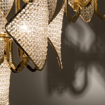 Lavish Patrizia Garganti Holly Units chandelier in glossy gold-toned metal crafted with luminous clear crystal elements