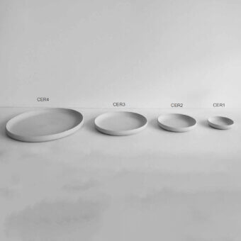 Distinguished Rina Menardi Cerchi plates crafted in baked clay with a smooth matte finish and neutral light gray hue