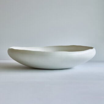 Exclusive Rina Menardi Luna centerpiece, a handcrafted decorative vessel sculpted in pale cream matte ceramic with organic form