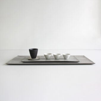Exceptional Rina Menardi Vassoi Rettangolari centerpiece tray with textured dark gray finish and minimalist design