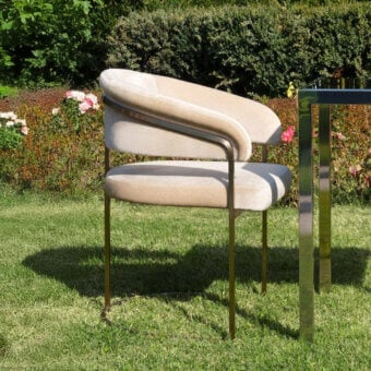 Distinguished Visionnaire Clem Outdoor armchair with gently curved form and pale beige upholstery crafted in satin brass and curved plywood