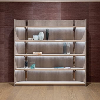 Superior Visionnaire Leonardo bookcase with warm taupe ‘canneté’ stripes, polished metal framing and light-toned wood shelving crafted in shaped MDF